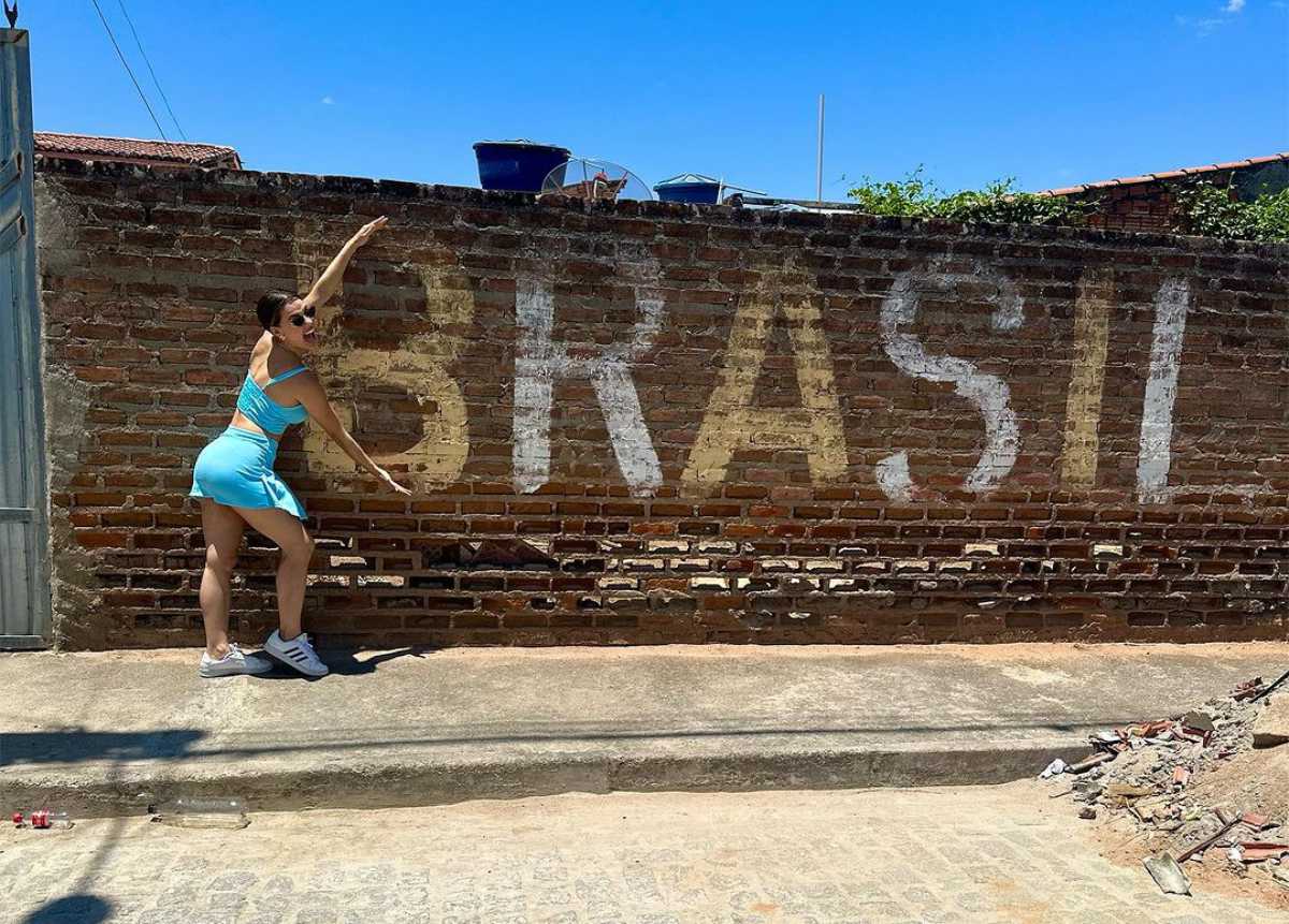 Beatriz Reis Brasil apontando para uma parede com seu bordão